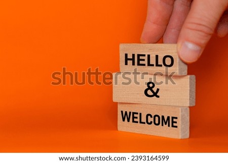Hello and welcome concept words arranged by businessman on wooden blocks. Welcome to the team, beautiful orange background. Copy space