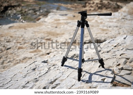 Tripod placed on a rocky shore.