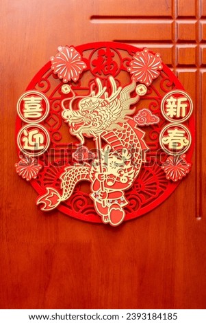 a Chinese New Year of the Dragon decoration on a door at vertical composition translation of the Chinese words are fortune and welcome to the new year no logo no trademark