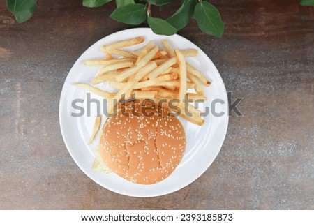 burger or pork burger or hamburger or beef burger , bun and French fries or fried potato