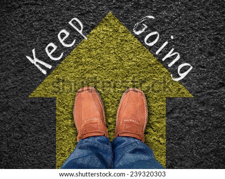 Inspiration quote : " Keep going" on aerial view of shoe on road with move forward blue arrow ,Motivational typographic