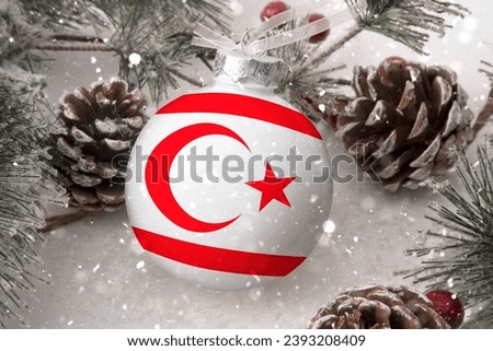 Christmas ball with the flag of Northern Cyprus, decorates the snow tree with snowfall. The concept of the Christmas and New Year holiday