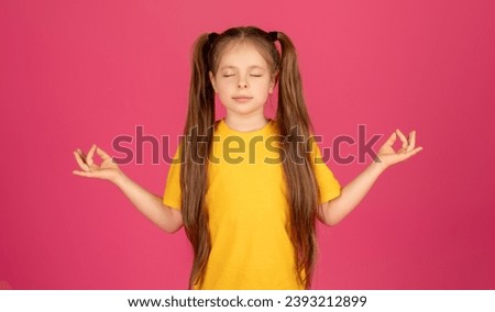 Calm preteen girl meditating with closed eyes, relaxed female kid standing isolated on pink studio background, kid practicing yoga and making zen mudra gesture with hands, copy space