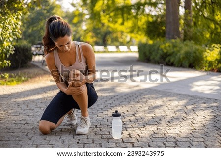 Woman runner hold her sports injured knee. Cropped Image of Woman Runner Hold Her Sports Injured Knee Outdoor. Injury From Workout Concept. Pain of Body Part and Bone Broken Theme Royalty-Free Stock Photo #2393243975