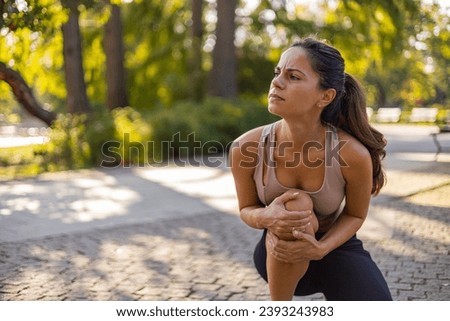 Woman runner hold her sports injured knee. Cropped Image of Woman Runner Hold Her Sports Injured Knee Outdoor. Injury From Workout Concept. Pain of Body Part and Bone Broken Theme Royalty-Free Stock Photo #2393243983