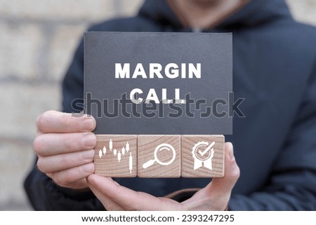 Man holding wooden cubes with icons and black sticky note with text: MARGIN CALL. Trading loss stock exchange. Brokerage account. Stock market crash margin call, down trend, big short.