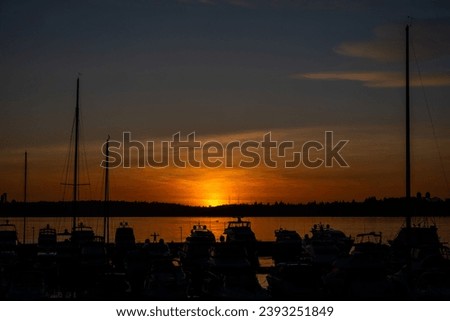 Sunset over Lake Washington, silhouette of marina and boat in foreground
