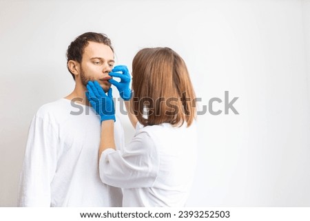 man with the disease urticaria, angioedema, an allergic reaction at an appointment with a dermatologist, immunologist, plastic surgeon. hyaluronic acid in the lip. Royalty-Free Stock Photo #2393252503