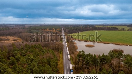 a queue of trucks waiting for border clearance at the road crossing between Poland and Ukraine Royalty-Free Stock Photo #2393262261