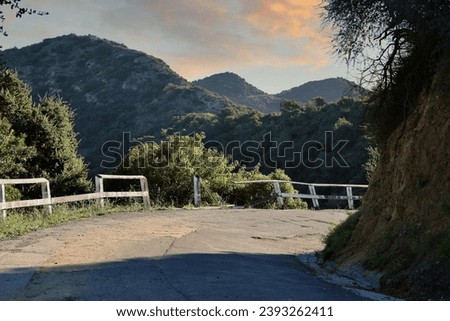 Broken wood fence on the sharp curve of a dangerous road Royalty-Free Stock Photo #2393262411