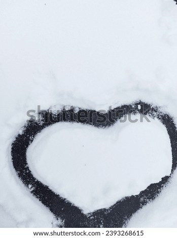Images of a heart in the snow. Winter natural background.