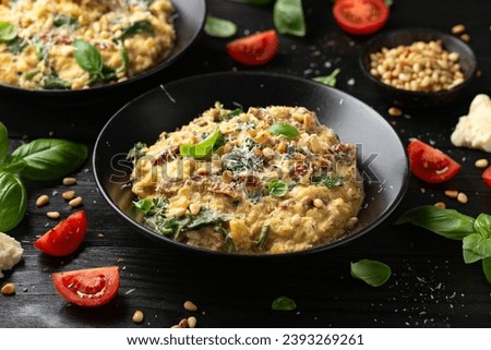 Creamy spaghetti squash pasta with parmesan cheese and sun dried tomato sauce served with pine nuts and basil. Royalty-Free Stock Photo #2393269261