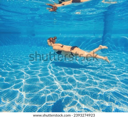 Pregnant serenity submerged a woman gracefully dives into the pool, celebrating the beauty of pregnancy with aquatic elegance Royalty-Free Stock Photo #2393274923