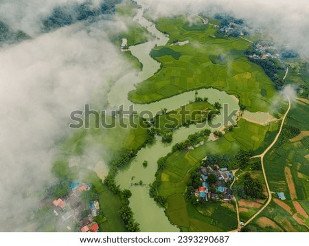Aerial view landscape in Phong Nam valley in cinematic sunrise with fog, an extreme scenery landscape at Cao bang province, Vietnam with river, nature, green rice fields. Travel and landscape concept.