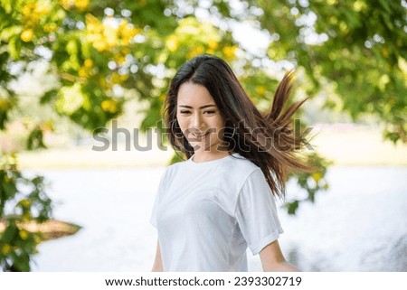 Happy Relax beautiful asian woman smiling face standing in green park outdoors garden. Young women enjoy nature morning Freedom Lifestyle. woman breathing fresh air and relax breath in green park
