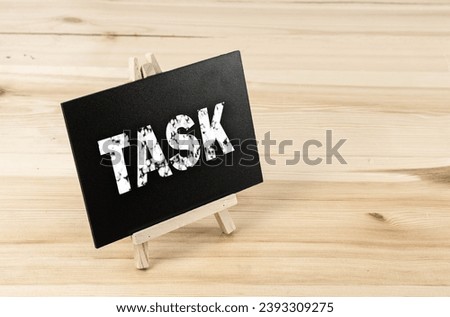 Text sign showing Task Job blackboard on white desk background.
Chalkboard words write Tasks symbol on table for copy space.