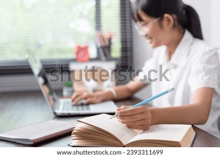 Educate at home. Asian school girl studying with books laptop preparing for test exam writing essay doing homework at home, Back to school.