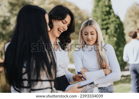 University students sharing knowledge and studying together in a sunny park. They exchange info, solve tasks, and prepare for exams, creating a successful, happy, and cooperative student life.