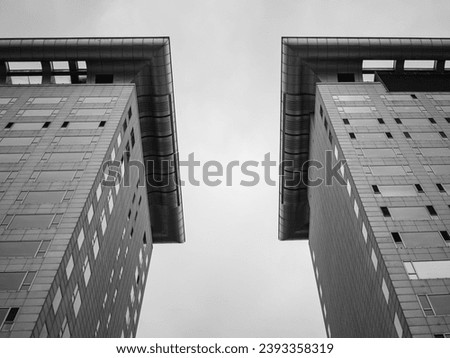A striking image of two tall towers, their geometric shapes and symmetry creating a sense of order and balance. The abstract concept of the image is juxtaposed against its minimalist structure...