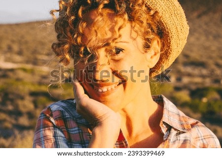 Confident and cheerful pretty adult female people smile and look at the camera in happy expression portrait. Mountains outdoors country side in background. Enjoyed person. Cute woman