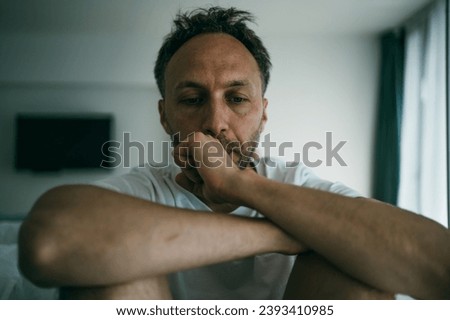 Sad middle age man alone at home. Emotional stress, burnout and midlife crisis concept Royalty-Free Stock Photo #2393410985