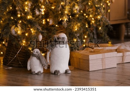 Cute penguin toys under the Christmas tree with lights