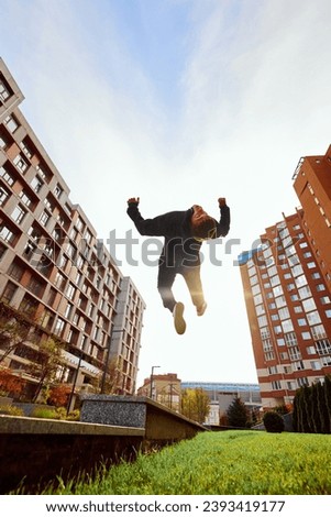 Fish eye effect photo of young man, guy performing insane jumps and breathtaking salto in air in action. Extreme sport activity, free running. Concept of lifestyle, sport, freestyle, activity, motion.