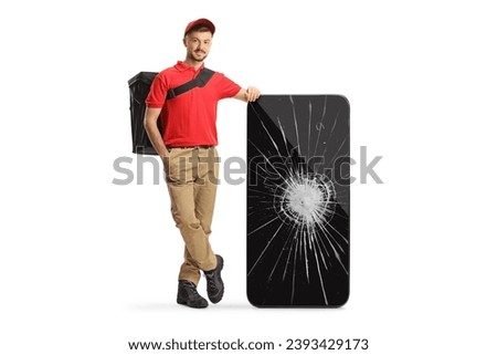 Delivery man leaning on a smartphone with a broken screen isolated on white background