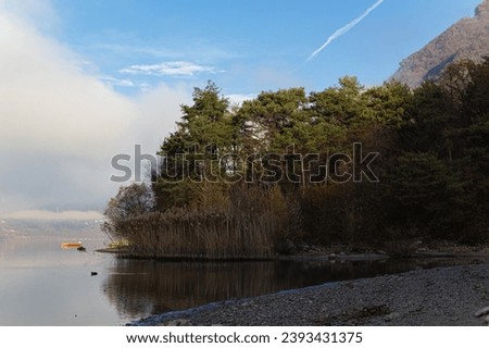 beautiful alpine lake in the morning in foggy and cloudy weather. Italian Alps. Vacation near a lake in Europe. Beautiful place of nature. Enjoying the views and landscapes.Morning in the mountains.