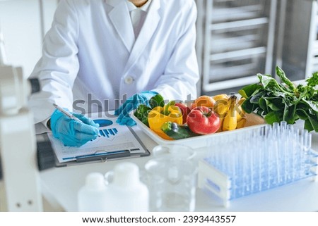 Researchers inspecting vegetables and fruits. Royalty-Free Stock Photo #2393443557