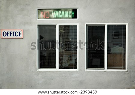 Old neon "No Vacancy" sign outside a motel office