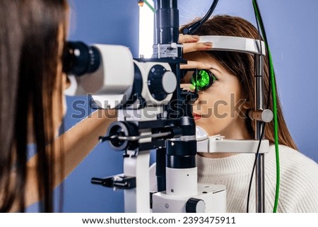 Eye examination and optometry to test your vision, medical consultation or glaucoma screening. Happy client with laser technology or eye scanning and ophthalmic test machine Royalty-Free Stock Photo #2393475911