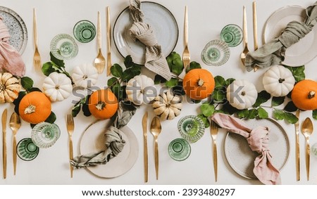 high angle decoration flat pumpkins white and orange, on white table with dishes and cups, thanksgiving concept. Royalty-Free Stock Photo #2393480297