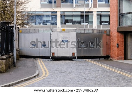 A metal mobile Police Cordon barrier blocks off a street in Belfast during a parade.