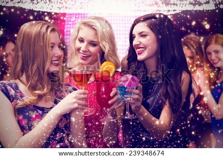Friends drinking cocktails against gold and red lights Royalty-Free Stock Photo #239348674