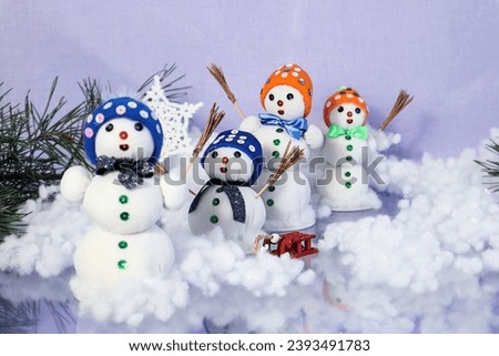 Christmas background: decorative snowmen on a pastel background, pine branches, bokeh, space for text