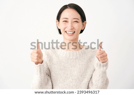 Asian middle aged woman thumbs up gesture in white background