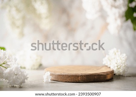 Geometric empty podium wooden platform stand for product presentation and spring flowering tree branch with white lilac flowers on pastel light background. Royalty-Free Stock Photo #2393500907