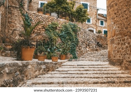 The old staircase in the cozy street of a small village Fornalutx in Mallorca, Spain Royalty-Free Stock Photo #2393507231