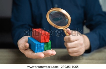 Examining cargo containers through a magnifying glass. Countering smuggling. Sanctioned goods. Prohibited products entering sanctioned countries through transit. Bypassing sanctions. Royalty-Free Stock Photo #2393511055