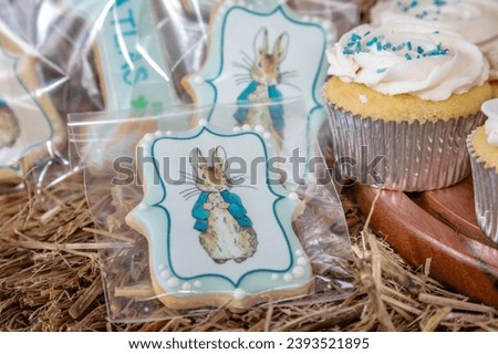 A close-up image of a decorated biscuit featuring a charming rabbit and a cupcake adorned with colorful sprinkles, each exuding a whimsical charm