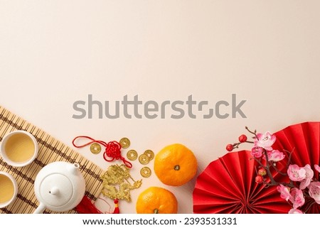 Chinese New Year's beauty from top view: fans, Feng Shui treasures, teapot set, and green tea—an ode to familial customs. Tangerines, sakura, pastel beige canvas create a perfect space for your text