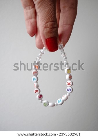 Selective focus. Friendship bracelets made of handmade plastic beads. Set of bright colorful braided bracelets with words. Colored ts teen jewelry. Royalty-Free Stock Photo #2393532981