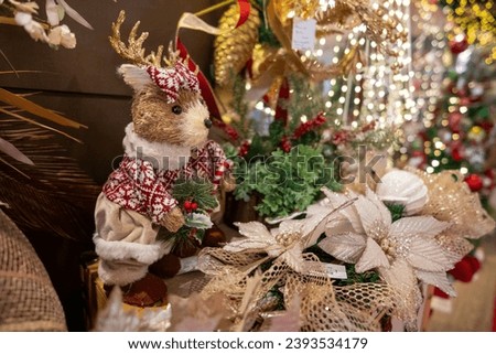 A stuffed animal is sitting next to a Christmas tree 