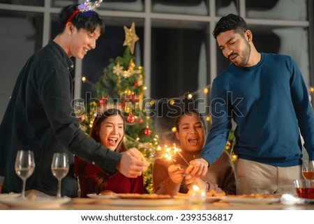 men and women holding sparkler fireworks in a party with Christmas tree. young couple Asian people enjoy celebrating Christmas and New Year. happy and celebrate with food wine and friendship for love,