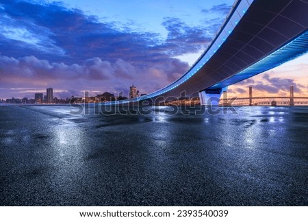 Asphalt road and bridge with city skyline at sunset in Macau