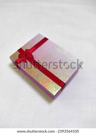 Glossy pink box with red ribbon 