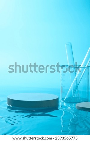A beaker containing test tubes displayed with an empty round podium. Pedestal or platform for beauty products presentation