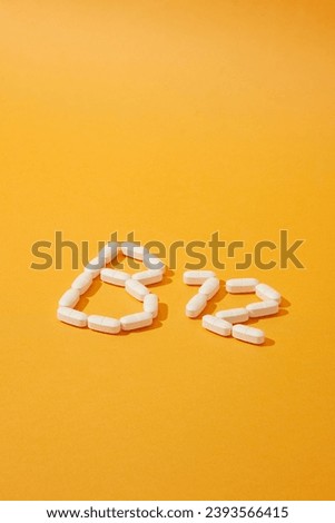 The white pills are arranged in the shape B12. Vitamin B12, also known as cobalamin, is a water-soluble vitamin. Image for vitamin product advertisement. Royalty-Free Stock Photo #2393566415