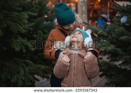 Cute little brother and sister at European Christmas market. Holidays. New Year.